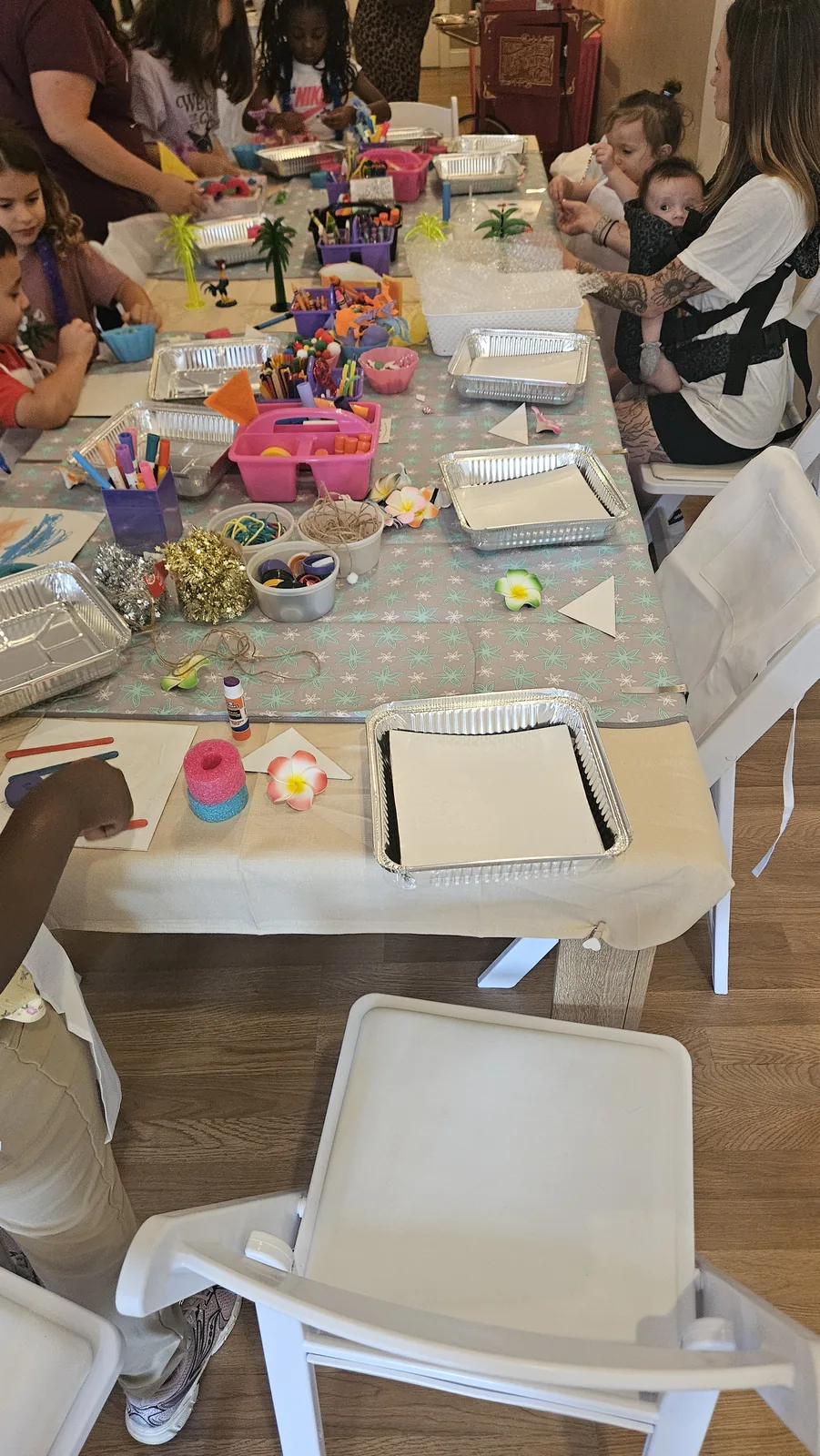 Long craft table covered with colorful supplies and projects during a STEAM Sprouts event