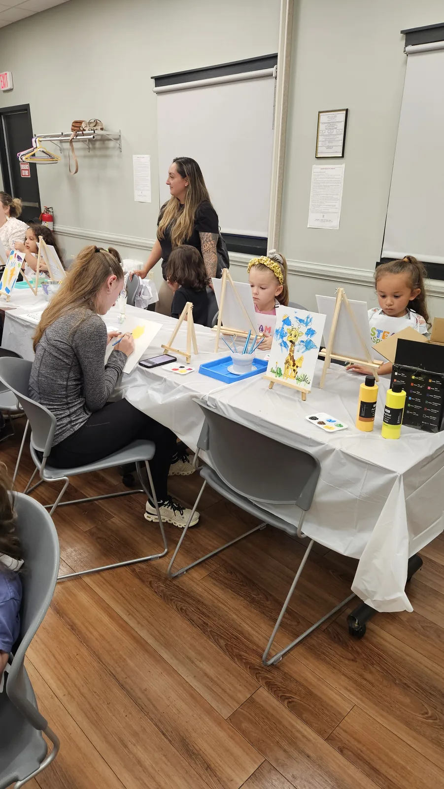 Families creating projects together at a STEAM Sprouts workshop table