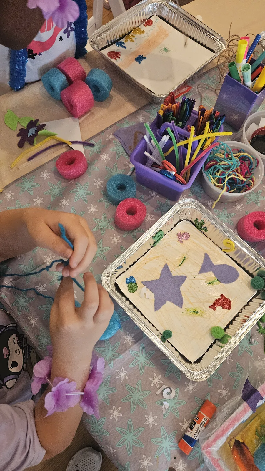 Close-up of colorful craft supplies and hands assembling a STEAM Sprouts project