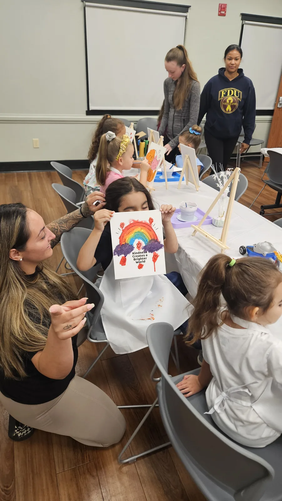 Children and adults painting and making colorful projects together at a STEAM Sprouts event