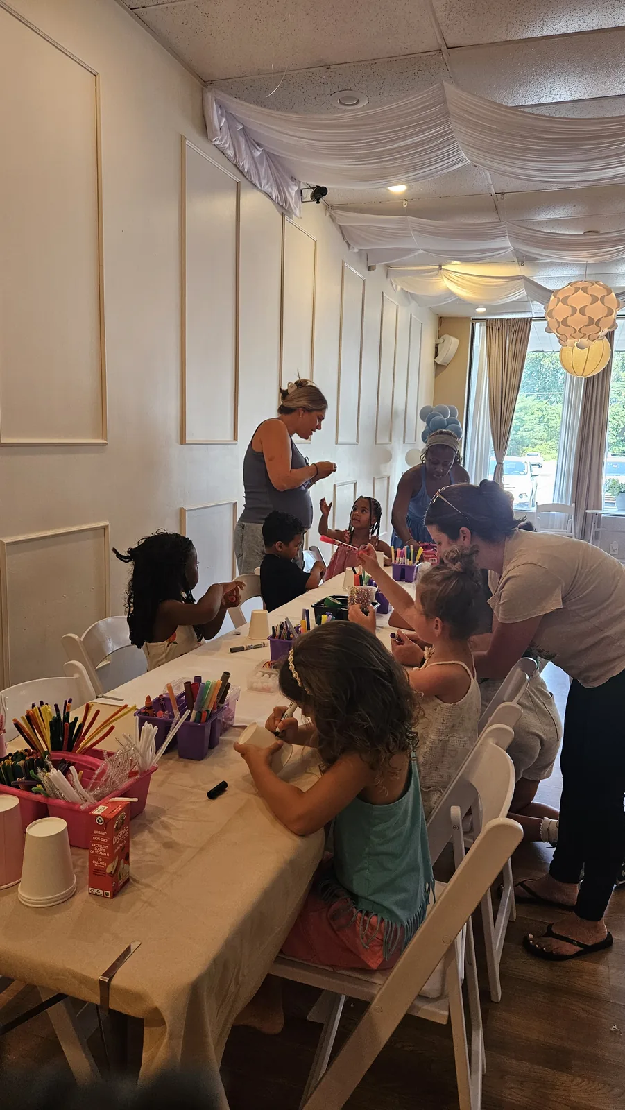 Children and adults painting and making colorful projects at a community craft event