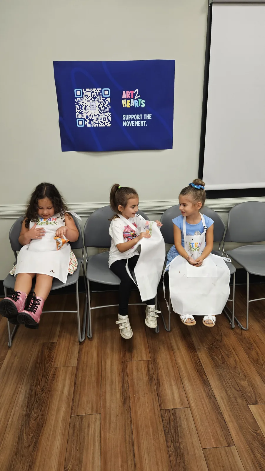 Children and adults working on colorful crafts at a STEAM Sprouts workshop